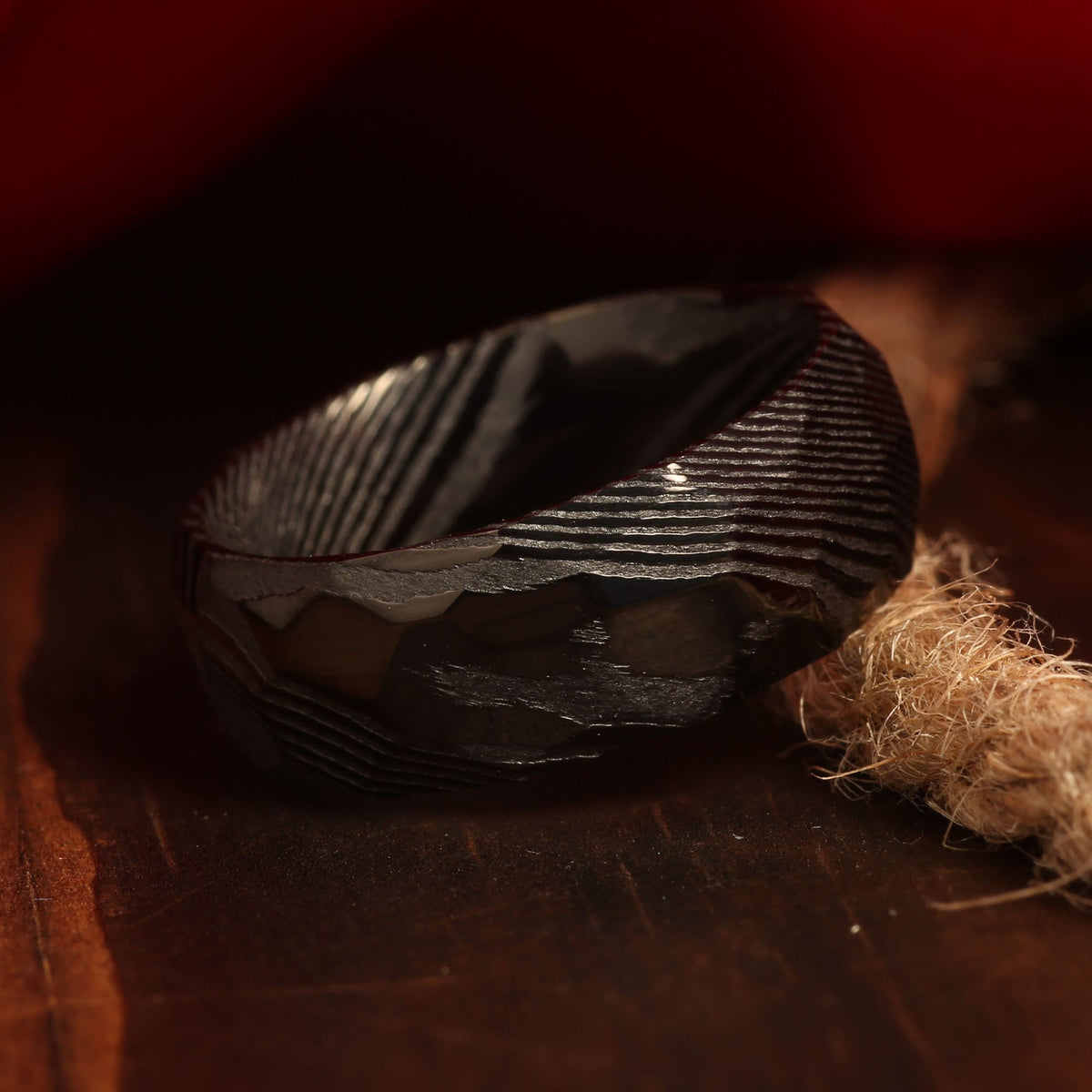 Black Damascus wedding ring for men with wood grain pattern