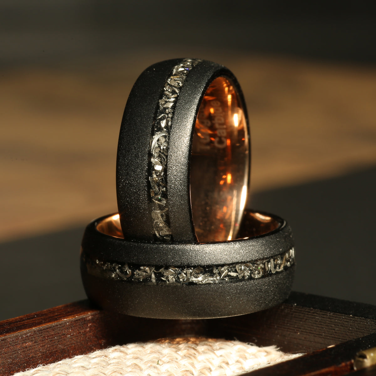 Men’s meteorite wedding band with black tungsten and rose gold interior